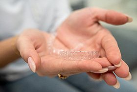 Closeup of patient holding clear aligner