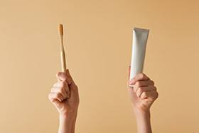 Hands holding a toothbrush and toothpaste 