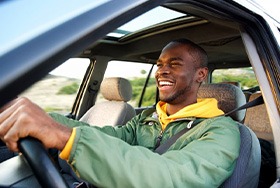 Man drives while smiling