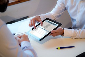 Patient and dental team member reviewing a dental insurance policy 