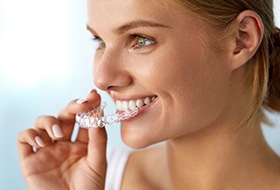 Woman placing Invisalign tray