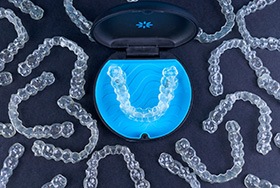 Bird’s eye view of Invisalign trays surrounding its carrier case