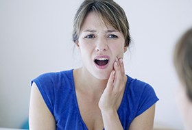 Woman in pain holding cheek