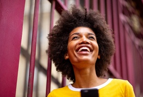 person smiling and holding out their phone