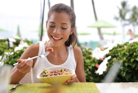 Woman smiling while eating lunch outside