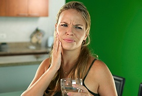 Woman holding cheek in pain