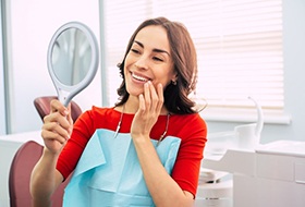 a patient checking her smile after teeth whitening