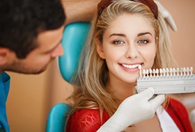 a patient checking her smile after teeth whitening