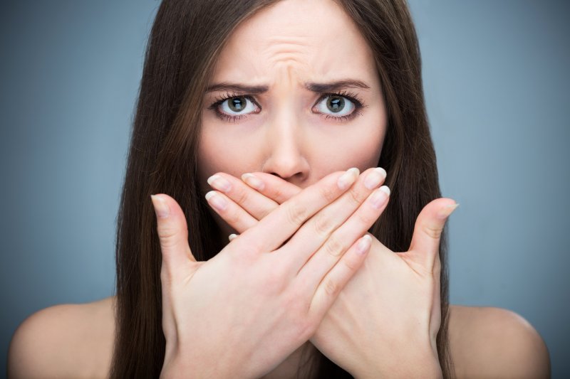 Woman covering cosmetic dental flaws