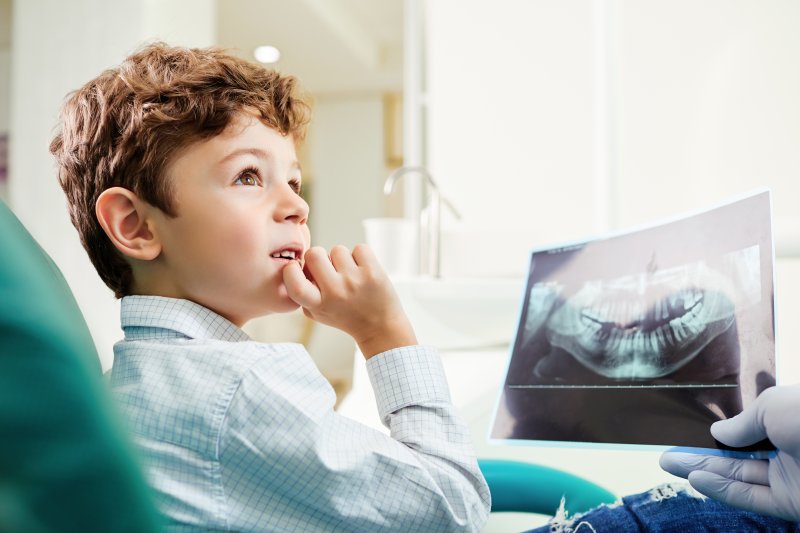 young child looking at x-ray of teeth