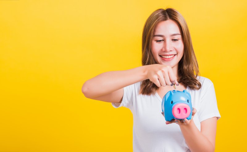 woman smiling and holding piggy bank in West Hartford