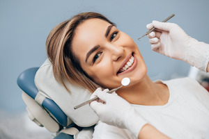 Woman having teeth examined and cleaned by dental hygienist