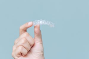 a patient holding their Invisalign tray