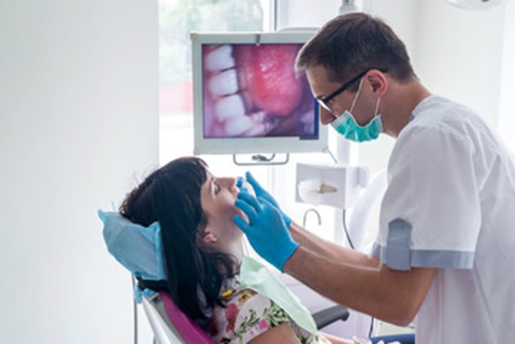 patient at dental appointment being screened for oral cancer