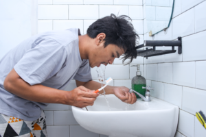 a person rinsing after brushing their teeth