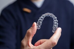 Man holding up an Invisalign clear aligner