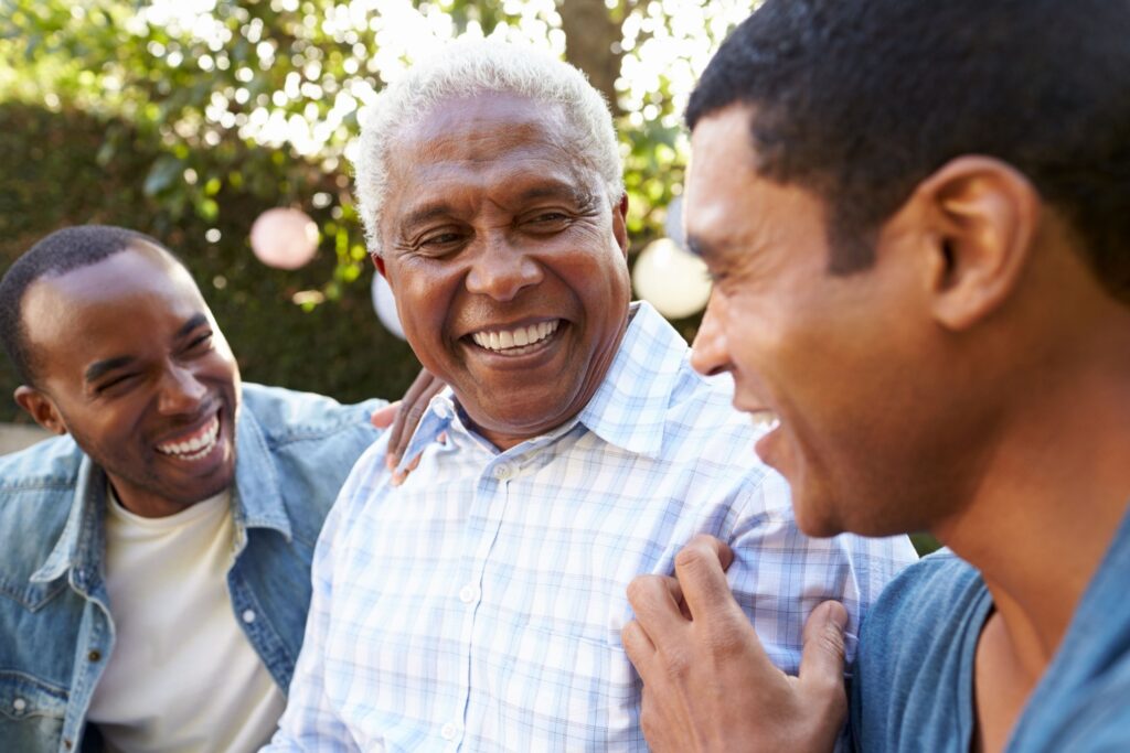 Three men outside talking and laughing together